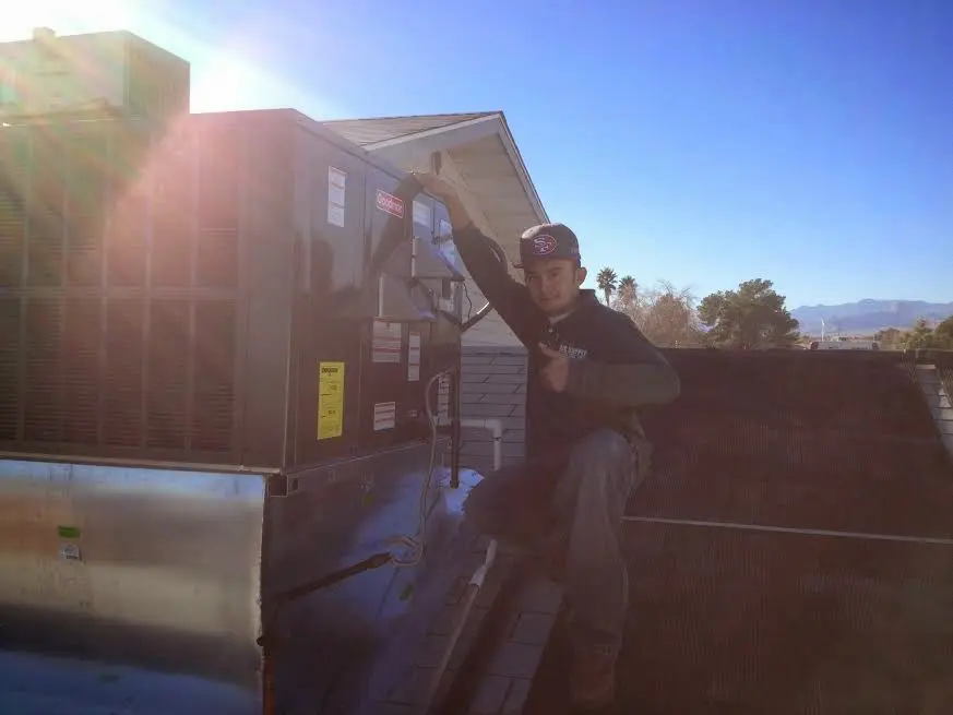 HVAC technician performing Heat Pump Repair on a rooftop unit in Bridgeport