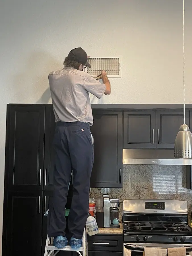 Technician inspecting an air vent during HVAC service in Bridgeport